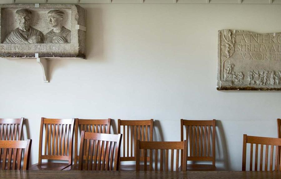 Photo of a seminar room space with casts on the wall and chairs lining a wood table.